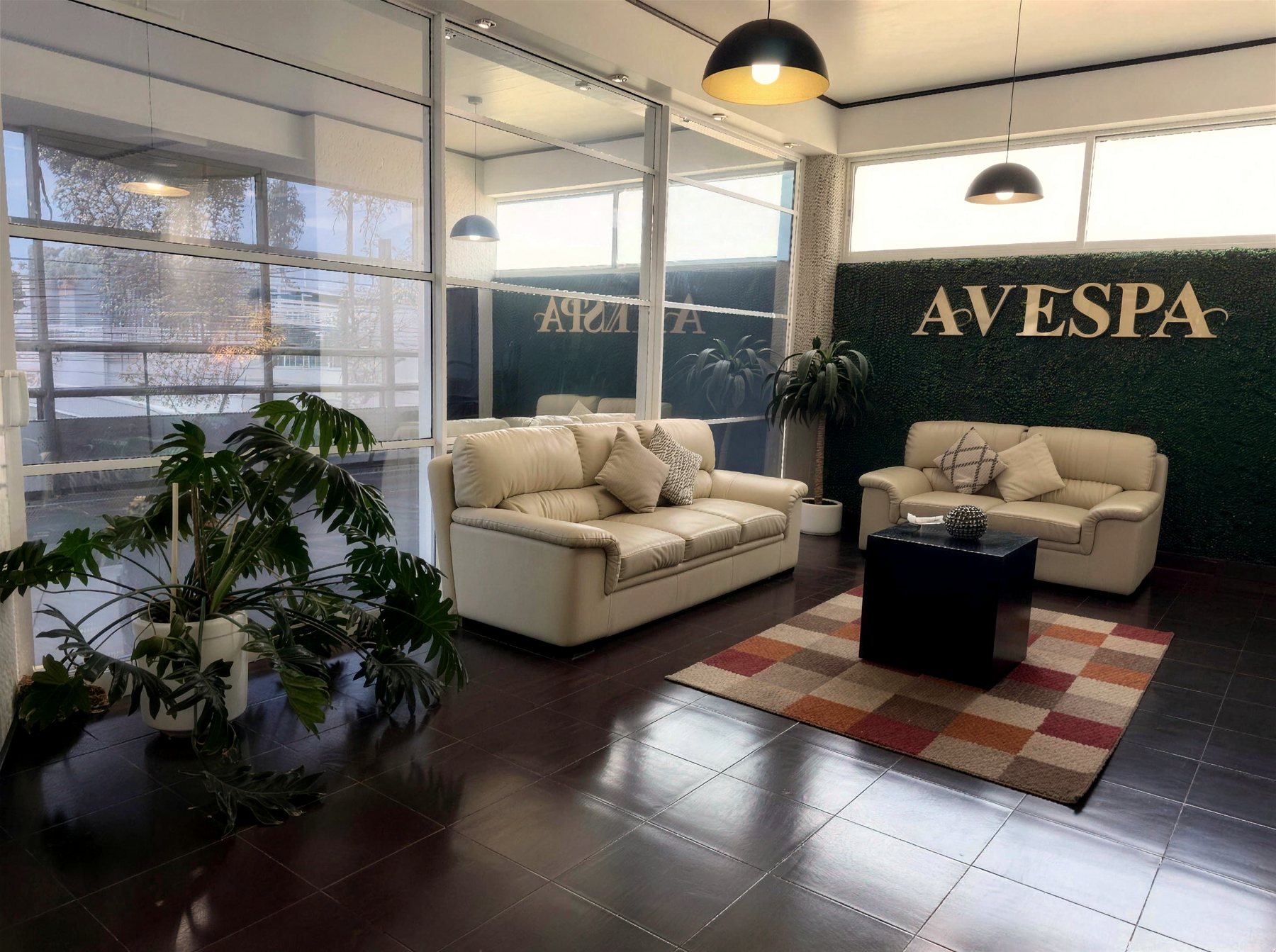 Sala de recepción de AVESPA con sillones blancos y el letrero dorado de la marca